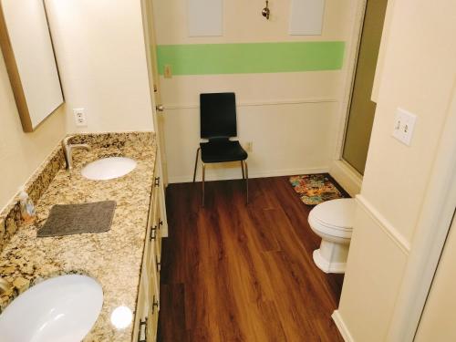 a bathroom with two sinks and a chair in it at Golden Sunflower's Apt E in Lawton