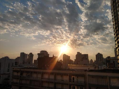 eine Skyline der Stadt mit der Sonne am Himmel in der Unterkunft Apartamento Top Vista mar Boqueirao Gonzaga in Santos