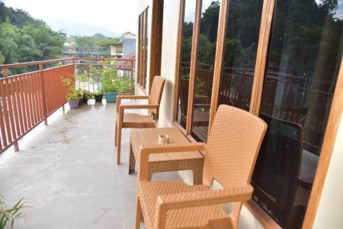 una fila de sillas y mesas en un balcón en Toraja Dannari Homestay en Rantepao