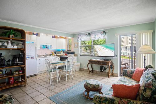 ein Wohnzimmer mit einem Sofa und einem Tisch sowie eine Küche in der Unterkunft Majestic Beach Condo with Heated POOL in St Pete Beach in St Pete Beach