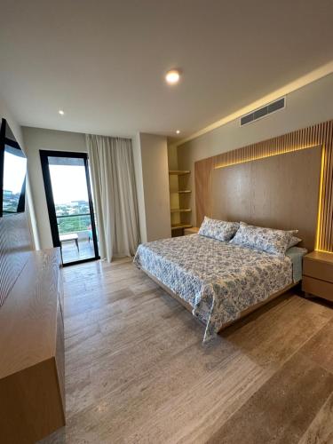 a large bedroom with a bed and a large window at Lujoso apartamento, Nuevo! in Cancún