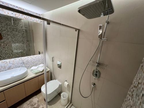 een badkamer met een douche, een toilet en een wastafel bij Mayan La Vie Yas Island 905 MB4 in Abu Dhabi