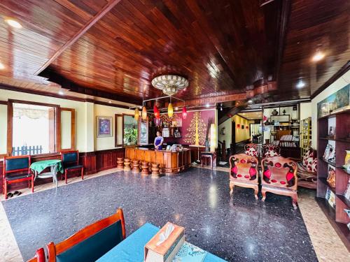 a large room with chairs and a bar in it at Visoun Luang Prabang Hotel in Luang Prabang