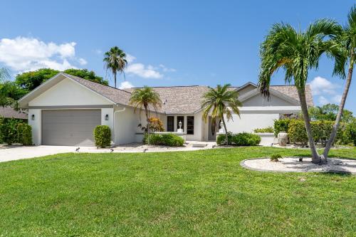 een huis met palmbomen in een tuin bij Beautiful Private Pool Home In-between Fort Myers Beach and Sanibel Island home in Fort Myers