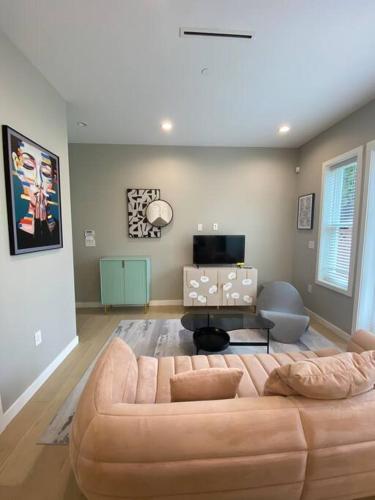 ein Wohnzimmer mit einem braunen Sofa in einem Zimmer in der Unterkunft New Modern Theee-room Duplex-2791 in Vancouver