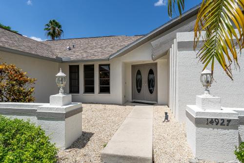 een wit huis met een voordeur en een oprit bij Beautiful Private Pool Home In-between Fort Myers Beach and Sanibel Island home in Fort Myers