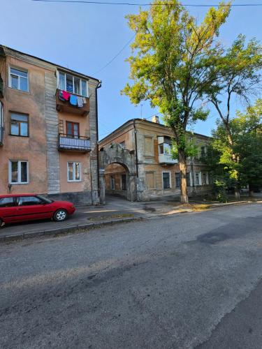 a red car parked in front of a building at Danyla Galytskogo apartment Центр міста, старе місто 5хв in Kamianets-Podilskyi