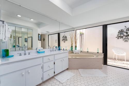 a bathroom with two sinks and a tub and a tubermott at Beautiful Private Pool Home In-between Fort Myers Beach and Sanibel Island home in Fort Myers
