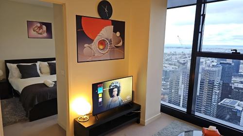 Schlafzimmer mit einem Bett, einem TV und einem Fenster in der Unterkunft Quick Aces Premium in Melbourne