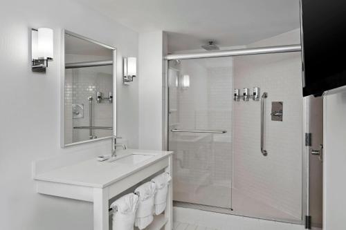 La salle de bains blanche est pourvue d'un lavabo et d'une douche. dans l'établissement Four Points by Sheraton Mall of America Minneapolis Airport, à Richfield