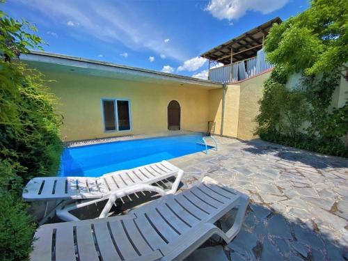 una piscina con 2 tumbonas y una casa en Large 5 bedroom VIP Villa 2, en Ereván