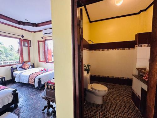 Habitación con baño con 2 camas y aseo. en Visoun Luang Prabang Hotel, en Luang Prabang