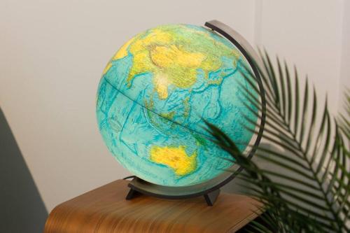 a globe sitting on a table next to a plant at #55highstreetauckland in Auckland
