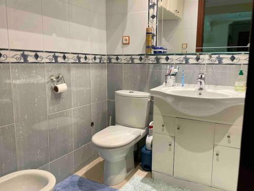 a bathroom with a white toilet and a sink at Appartement de standing calme en centre ville IMAZUR in Tangier