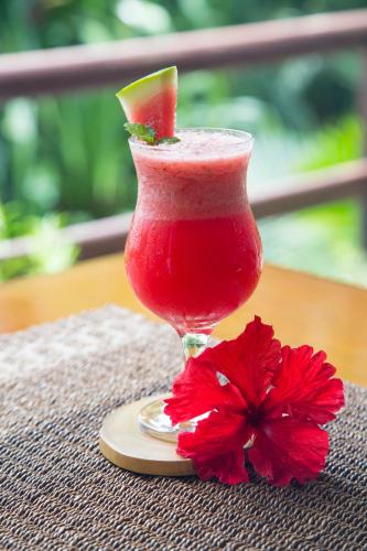 a drink with a slice of watermelon and a red flower at Mandala Spa & Resort Villas in Boracay