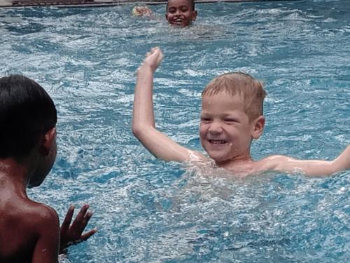 a young boy swimming in a swimming pool at Ibis in Udawalawe