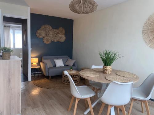 un salon avec une table, des chaises et un canapé dans l'établissement Les anges bleus, au Tréport