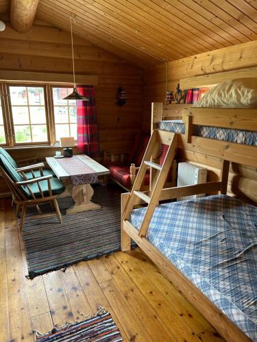 um quarto com 2 beliches e uma mesa num camarote em Atnasjø Kafe AS em Sollia