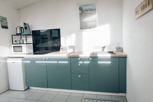 eine Küche mit blauen Schränken und einem Waschbecken in der Unterkunft Ti salé 1 in L'Étang-Salé-les-Bains