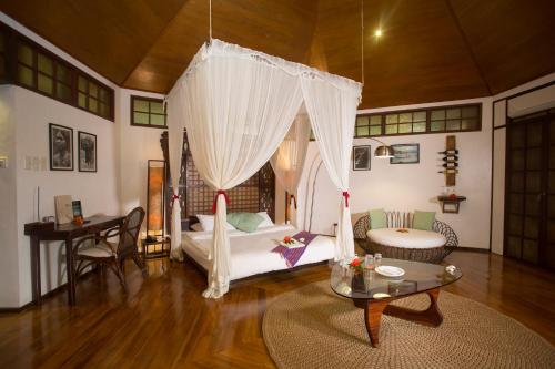 a living room with a bed and a table at Mandala Spa & Resort Villas in Boracay