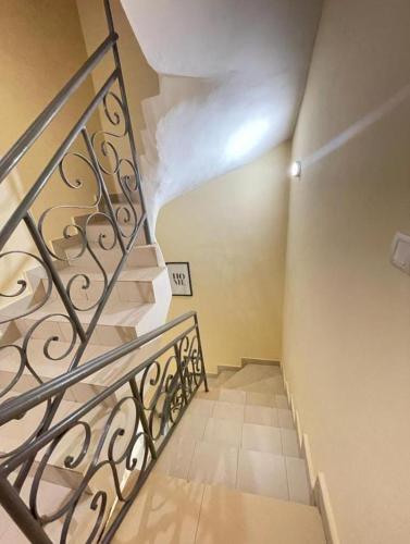 a staircase with a metal railing in a room at AGIM-GUESTHOUSSE in Abomey-Calavi