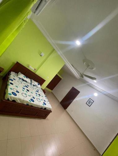 Cette petite chambre comprend un lit dans l'angle d'une pièce. dans l'établissement AGIM-GUESTHOUSSE, à Abomey-Calavi