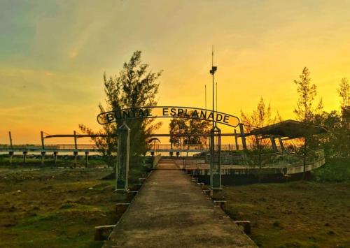 a sign for the entrance to a beach with the sunset at Raniah homestay in Kuching
