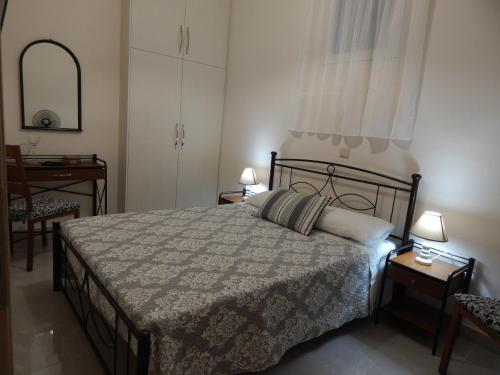 a bedroom with a bed and a table and a mirror at Vera City Apartment in Zakynthos