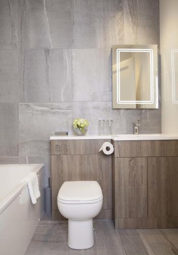 a bathroom with a toilet and a sink and a mirror at The Orchid Hotel in Bournemouth