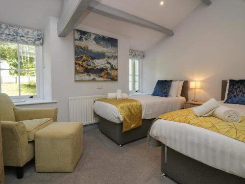 una habitación de hotel con 2 camas y una silla en Greta House en Keswick