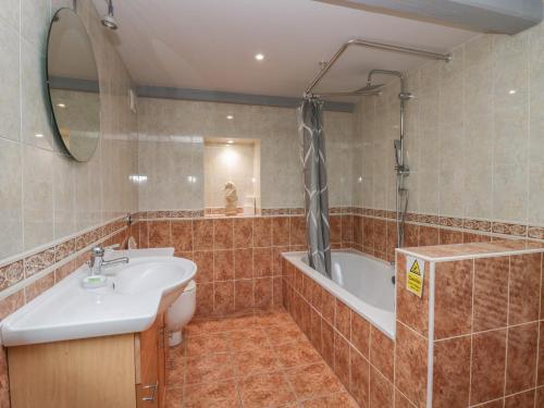 a bathroom with a sink and a bath tub at Greta House in Keswick