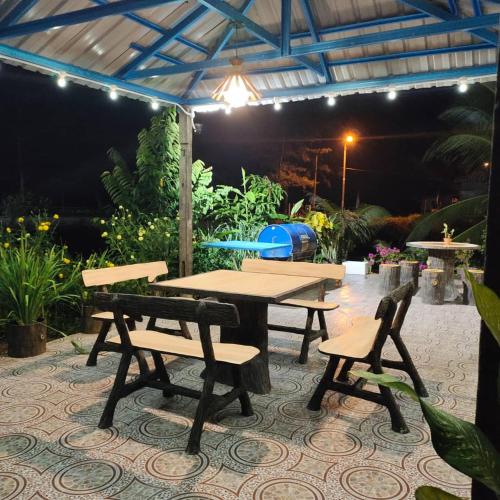 a picnic table and benches on a patio at night at Raniah homestay in Kuching