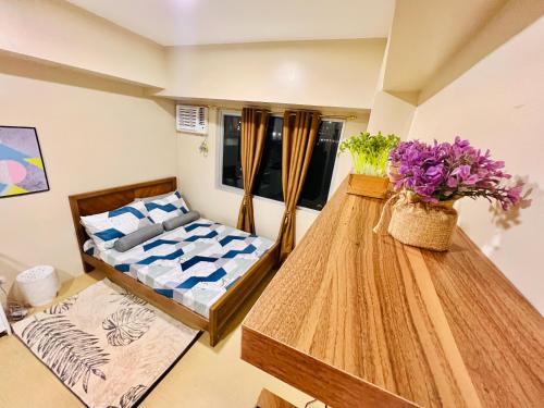 a bedroom with a bed and a table with flowers at * * *N Affordable Urban Luxury in Iloilo City
