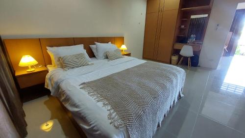 a large bed in a bedroom with two lamps at Cozy Apartment Chaweng Center in Chaweng