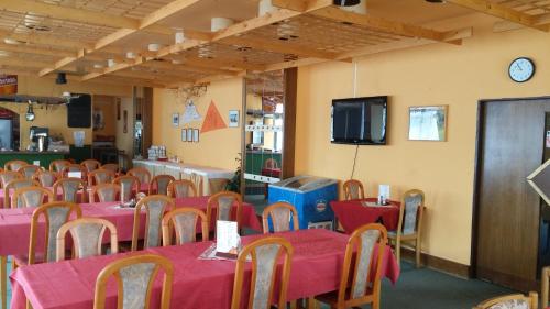 Hotel Nico في سبيندلروف ملين: غرفة بها طاولات وكراسي وتلفزيون