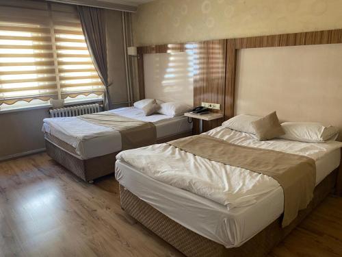 a hotel room with two beds and a window at PİTHANA OTEL in Corum