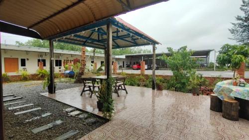 un patio con una mesa y sillas bajo la lluvia en Raniah homestay en Kuching