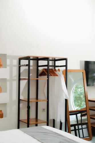 a room with a shelf with a table and a mirror at The Volter Yogyakarta in Ngingas