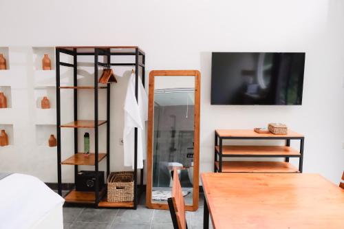 a room with a mirror and a table and a tv at The Volter Yogyakarta in Ngingas
