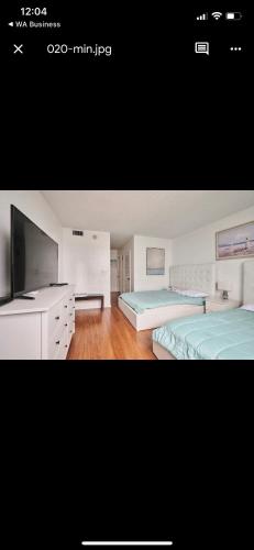 Un dormitorio grande con dos camas y un televisor. en Apartments TVG Miami by the ocean !, en Miami Beach