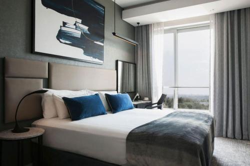 um quarto com uma cama grande e uma janela grande em 1 Bedroom Luxury Apartment in Luxury Hotel & Apartments in Sandton Central em Joanesburgo