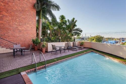 a swimming pool on a patio with a table and chairs at Protea Hotel by Marriott Lusaka in Lusaka