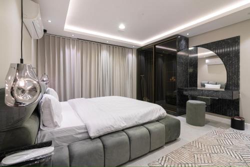 1 dormitorio con 1 cama blanca grande y chimenea en كمباوند تليد - حطين - الملقا - بوليفارد, en Riad
