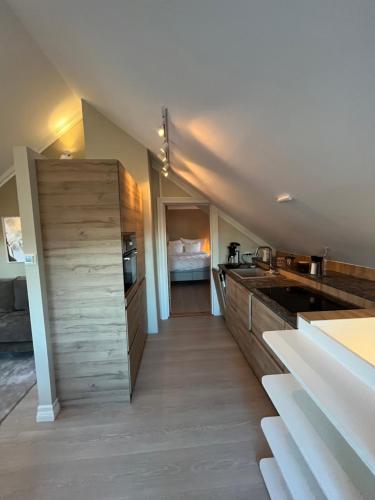 a kitchen with wooden cabinets and a bed at Bo i historisk bygning, kort vei til sentrum in Trondheim