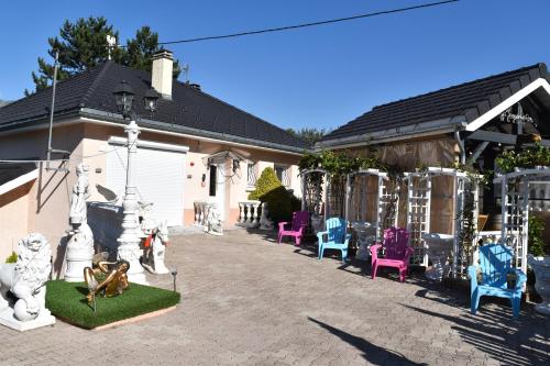 un grupo de sillas y mesas frente a una casa en Gîte Au Clair Matin ,la Mure, les passerelles Monteynard, en Pierre-Châtel
