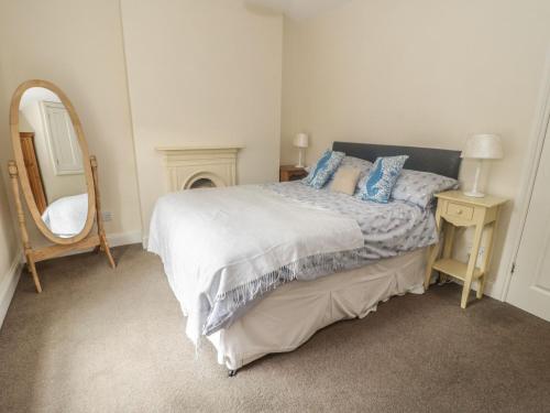 1 dormitorio con 1 cama grande con espejo y espejo en Ty Potiwr, en Conwy
