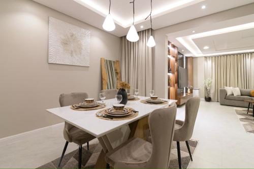 كمباوند تليد - حطين - الملقا - بوليفارد في الرياض: غرفة طعام مع طاولة بيضاء وكراسي