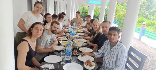 a group of people sitting at a table eating food at Jewel Homes Thattekad - ISO 9001 certified Birding & Family Nature Stay in Thattakād