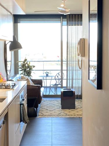 a kitchen and living room with a view of the ocean at Stylish Central Lake View Apartment - free parking in Canberra