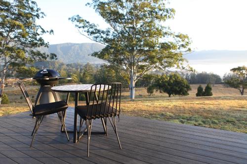 a table and chairs on a deck with a grill at Avion Retreat in Pumpenbill